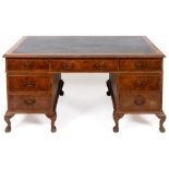 An 18th century style walnut pedestal desk, the leather inset top above an arrangement of seven