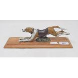 A painted bronze running dog paperclip, on an oak base, 28 cm wide Modern