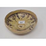 An Indian pottery bowl, decorated scrolls in manganese, restored, 18 cm diameter