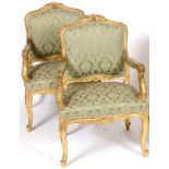 A pair of French Louis XVI style giltwood armchairs, carved flowers and foliage, on cabriole legs (