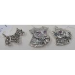 A silver brooch, in the form of a dogs head, another similar, and another in the form of a