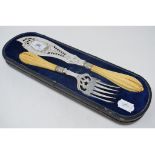 A pair of silver plated fish servers, with carved ivory handles, inscribed A Warde, cased