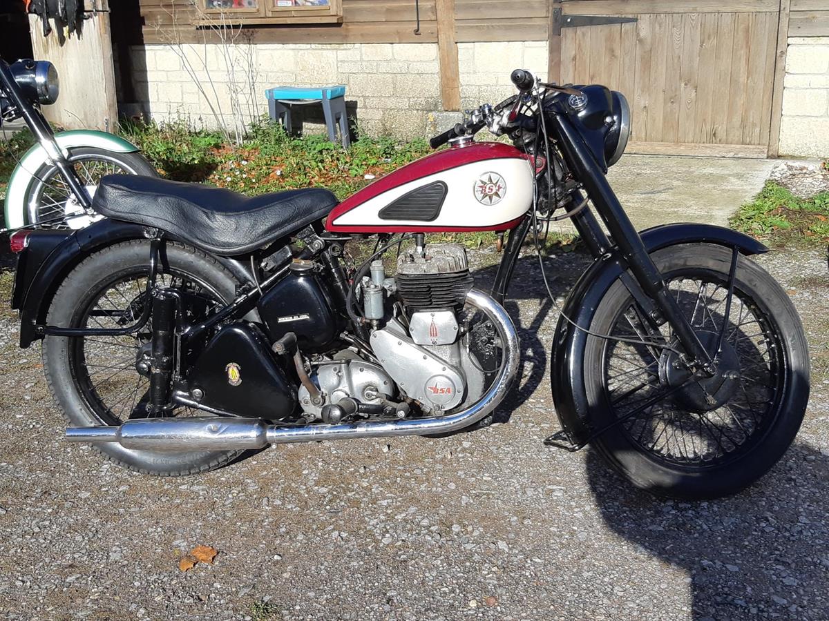 A 1954 BSA M21, registration number 897 UYX, red/black. The large sidevalve BSA was reintroduced