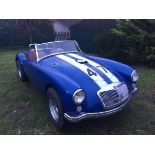 A 1959 LHD MG A roadster, US registered, blue with racing white stripes.