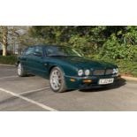 A 2002 Jaguar XJR saloon, registration number EJ02 MHV, green. This automatic supercharged Jaguar