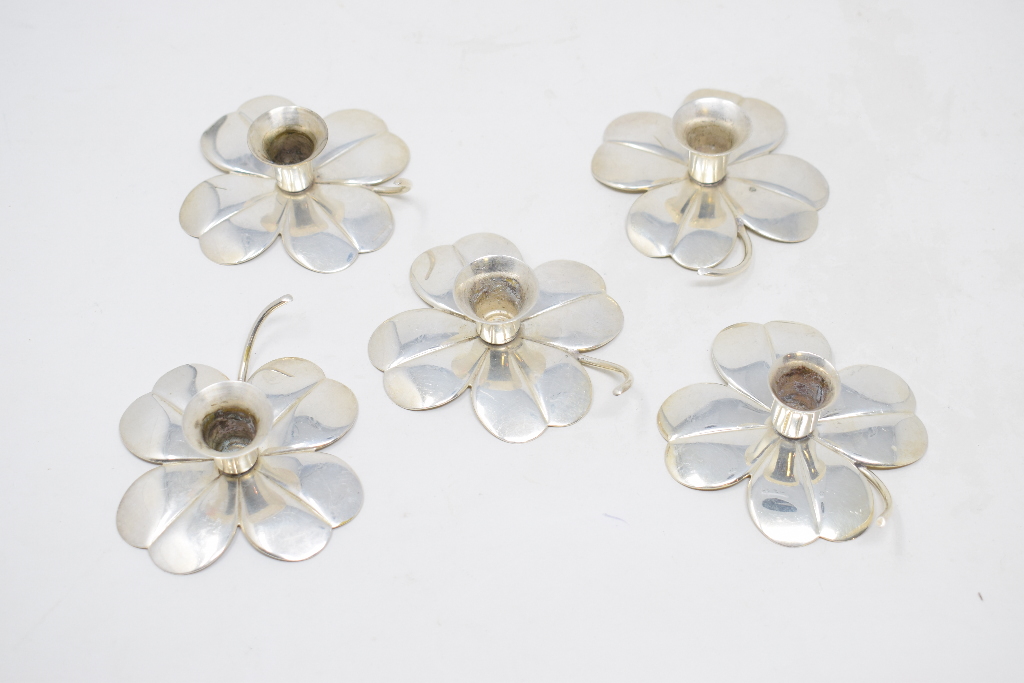 A set of five Swedish silver coloured metal candle holders, in the form of flowerheads, 8 cm wide,