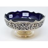 A George V silver pedestal bowl, with pierced foliate decoration and blue glass liner, Barker