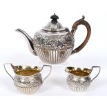 A Victorian silver three piece tea service, with scrolling foliage border embossed bird heads,