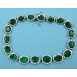 An 18ct white gold emerald and diamond bracelet, set oval and cushion cut stones See illustration
