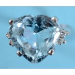 A large heart shaped aquamarine ring, the central stone flanked by two brilliant cut diamonds, in