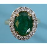 An 18ct gold, oval emerald and diamond cluster ring, approx. ring size M½ See inside front cover