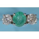 An emerald and diamond three stone ring, in a white coloured metal mount, approx. ring size K See