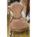 A Victorian walnut button back nursing chair, with carved decoration