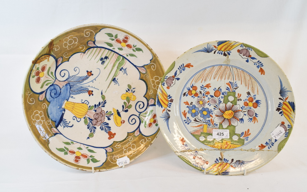 A Dutch polychrome Delft plate, decorated a vase of flowers and a bird, 33.5 cm diameter, and