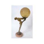 An Art Deco lamp, in the form of a figure on tiptoes holding an orb, signed Le Verrier, on a