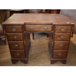 An Edwardian inlaid mahogany desk, of inverted breakfront form, the leatherette inset top above an