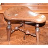 A Victorian mahogany saddle or bum stool, cut down