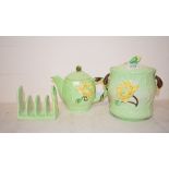 A Carlton Ware Yellow Lily teapot and cover, 1786 (?), 13 cm high, a similar toast rack, a biscuit