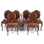 A set of six Victorian carved walnut dining chairs, with upholstered backs and seats, on cabriole
