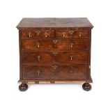 A chest, veneered in walnut, crossbanded, having two short and three graduated long drawers, on