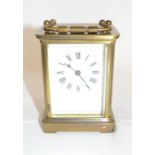 A carriage timepiece, the enamel dial with Roman numerals, in a brass four pillar case, 14 cm high
