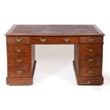 An Edwardian mahogany pedestal desk, the leatherette inset top above an arrangement of eight