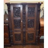 An oak cupboard, incorporating 19th century panels carved figures, flowers and foliage, with two