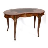 A Victorian burr walnut kidney shaped writing table, crossbanded, on brass capped cabriole legs,