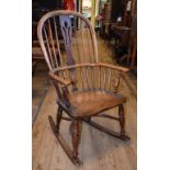 A late 19th century kitchen stick back rocking armchair, with a crinoline stretcher