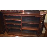 A late Victorian walnut open bookcase, having open shelves flanked by panel doors and mirrored