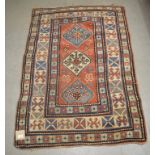 An Eastern rug, decorated a central lozenge and floral motifs on a red ground, within a multi