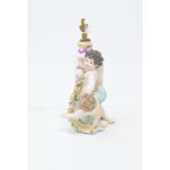 A Continental porcelain scent bottle, in the form of two putti with a flower garland, with gilt