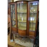 An Edwardian inlaid mahogany display cabinet, with central bow front section, on tapering legs,