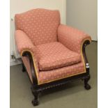 An upholstered armchair, on cabriole legs with claw and ball feet