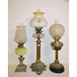A large brass table lamp, with clear glass reservoir, 81 cm high, and two others, 66 cm and 63.5