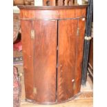 A George III bow front mahogany hanging corner cupboard, 75 cm wide