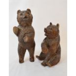 A Black Forest carved wood bear, seated, some chips, 17 cm high, and another similar (2)