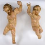 A pair of Continental painted and gilded hanging putto, approx. 60 and 65 cm high (2) See