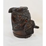 A Black Forest style carved wood tobacco jar, in the form of a smoking dog, with glass eyes, 18 cm