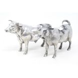 A Continental silver coloured metal model of a bull, probably 19th century, and a similar cow,