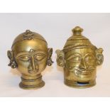 An Indian brass head of Shiva, 14 cm high, and another Indian brass head, slight loss, 15 cm high (