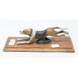 A painted bronze running dog paperclip, on an oak base, 28 cm wide Report by RB Modern