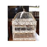 A painted metal bird cage, containing two carved wood painted birds, 36 cm wide, hanging scales,