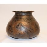 An Islamic brass vessel, of compressed baluster form, decorated foliage and calligraphy, 12 cm high