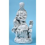 A Chinese Blanc de Chine figure, of Guanyin seated, wearing robes, the left arm cradling a ruyi