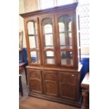 A Continental side cabinet, having a glazed upper section above three panelled doors, 131 cm wide,