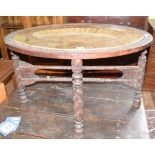 An Indian carved wood table, inset an oval brass tray, 86 cm wide