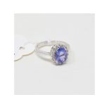 An oval tanzanite and diamond cluster ring, in a white coloured metal mount, approx. ring size KÂ½