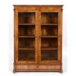 A 19th century German walnut cabinet, having a pair of glazed doors enclosing shelves, 119 cm wide