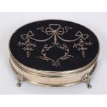 An early 20th century oval silver and tortoiseshell trinket box, inlaid with ribbons, swags and
